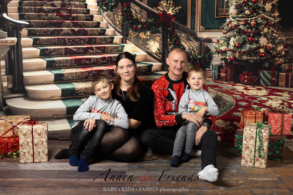 Weihnachts-Shooting mit Familie vor weihnachtlich geschmückter Treppe